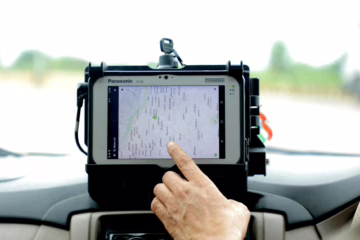 hand touching gps tracker in car