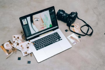 a laptop beside a black camera